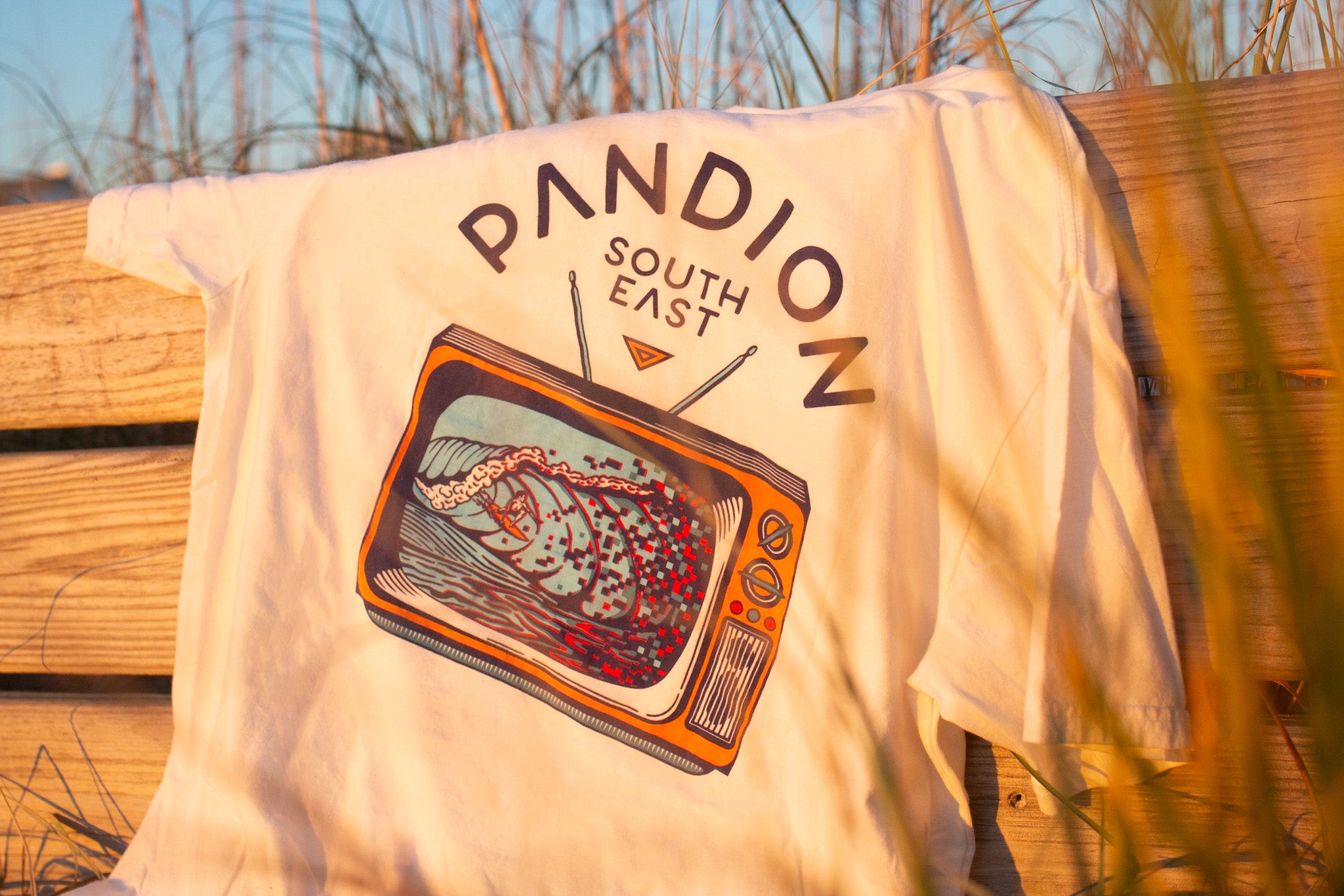 white pandion tee handing on beach bench